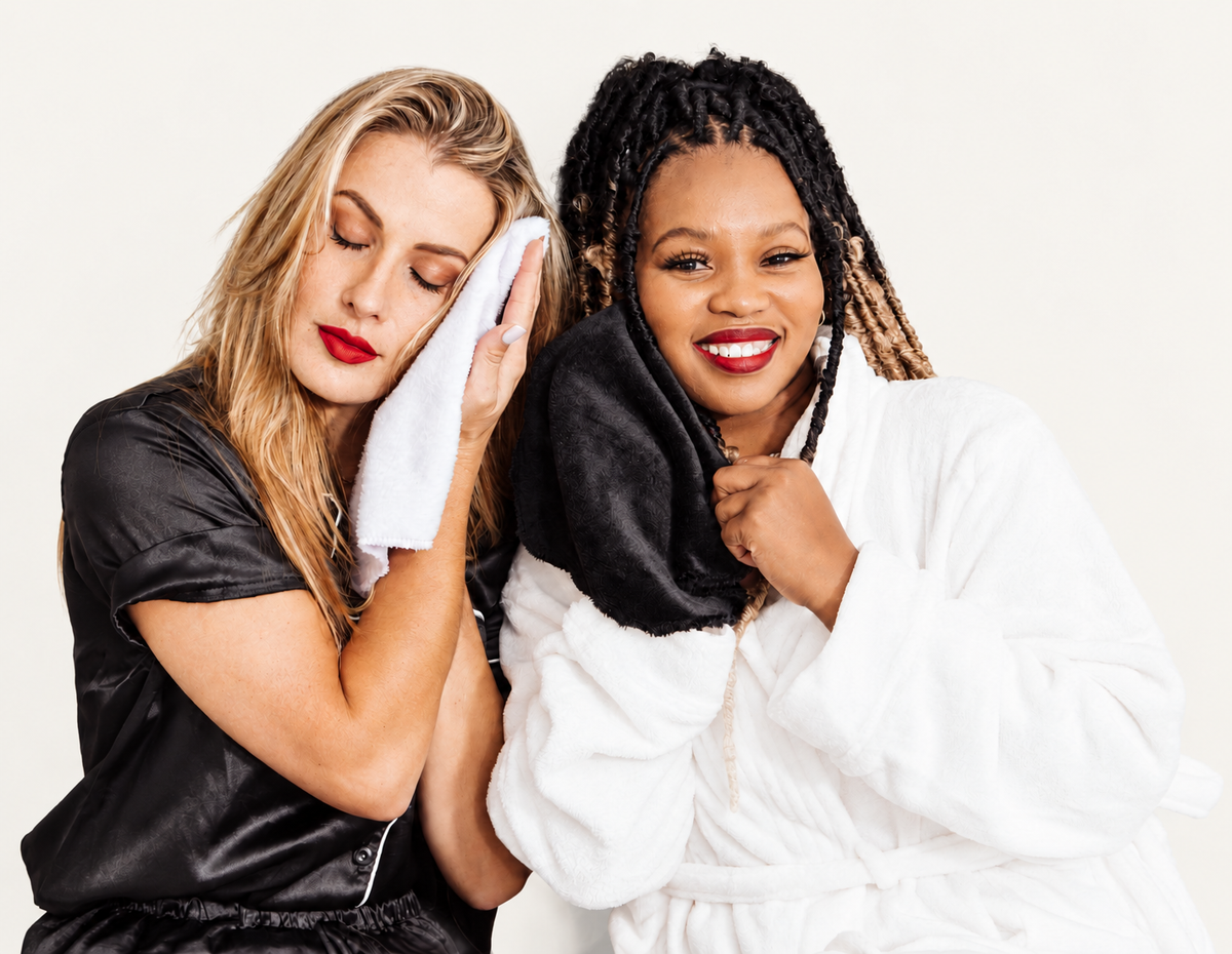 Two smiling women using KC Cloths reusable microfiber face cloths, one white and one black